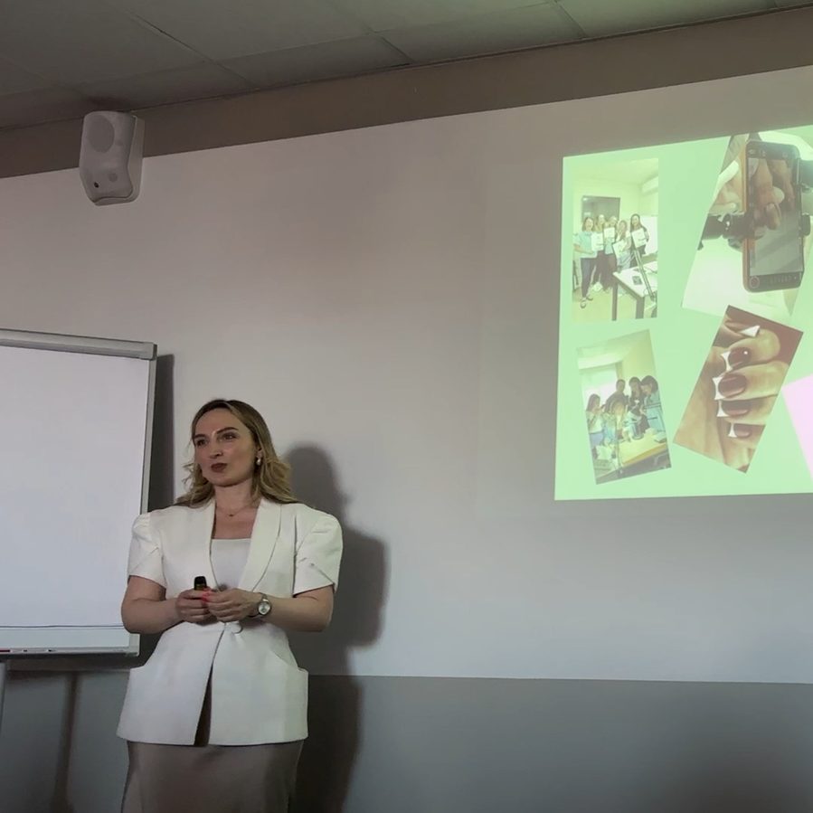 Salome speaking on stage at a beauty industry event